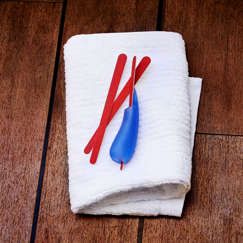 multipurpose grip sitting on hand towel with disposable nail file inserted