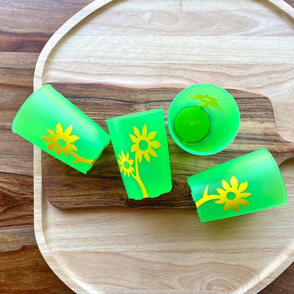 green plastic non slip cups on wooden boards