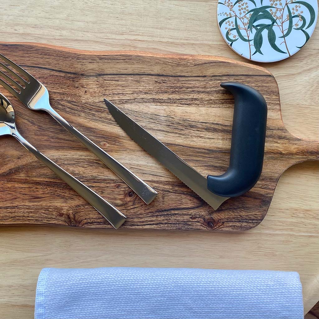 angled steak knife on wooden chopping board