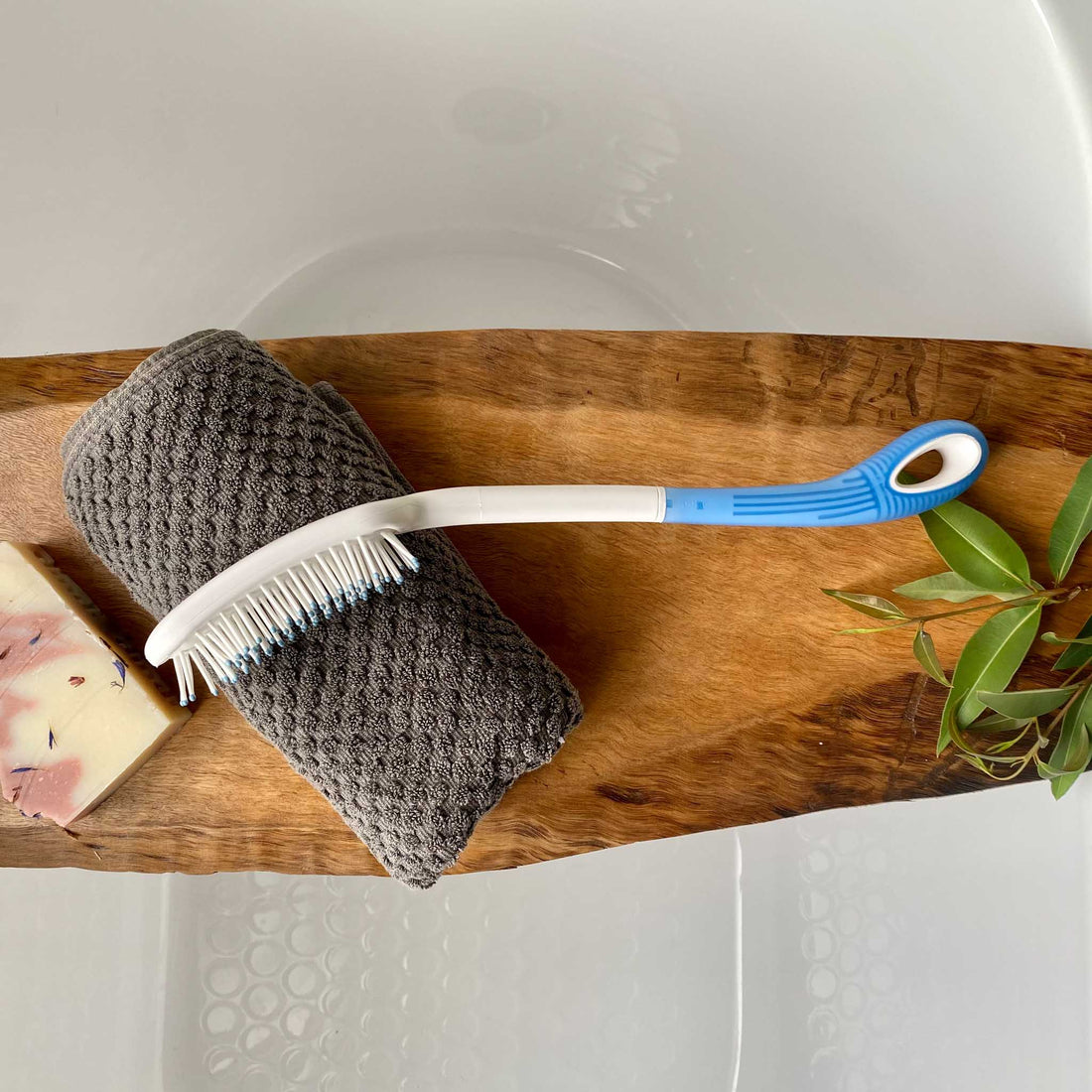 long handled brush on wooden bath rail