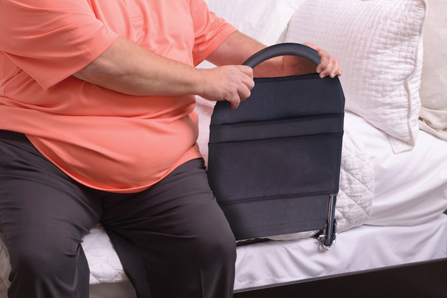 larger person using mounted bed rail to stand out of bed
