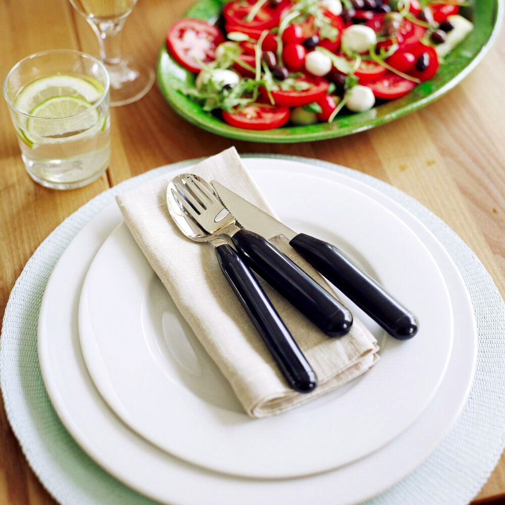 thick handled cutlery on table top with plates and serviette