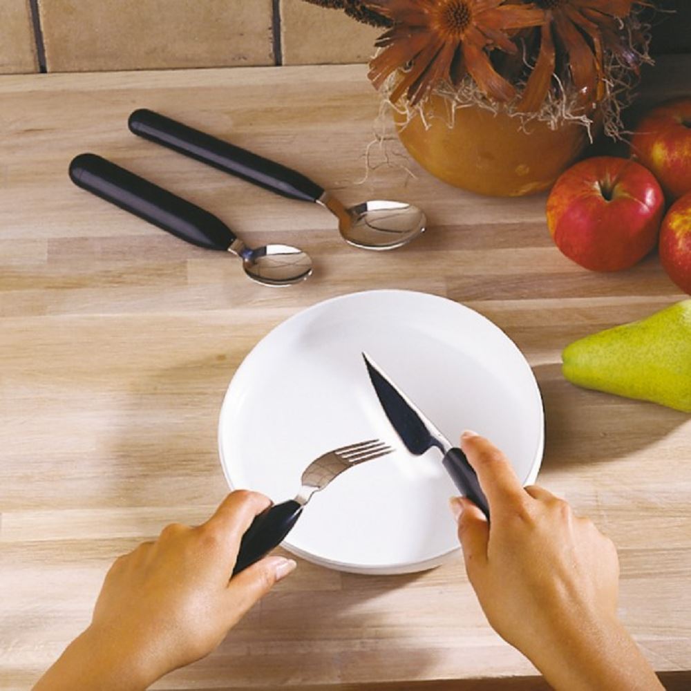 thick handled cutlery on table top with plate and fruit