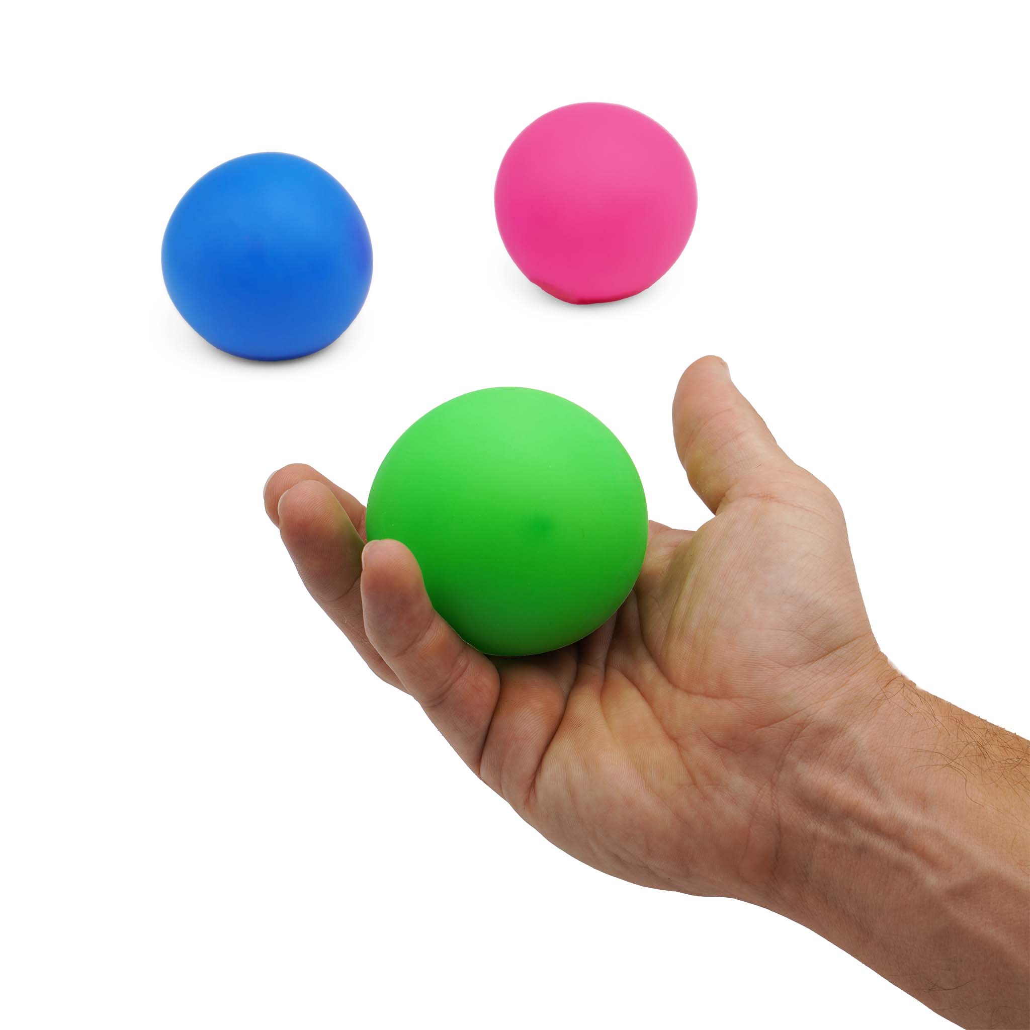 green sensory squishy ball held in hand with blue and pink sensory squishy balls in the background