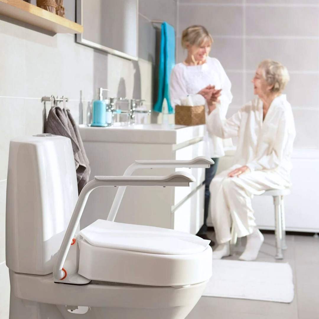 Etac Hi-Loo toilet seat raiser with armrests in the 10 cm variant mounted on toilet in bathroom