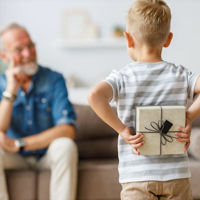 Child holding gift behind back for Grandfather