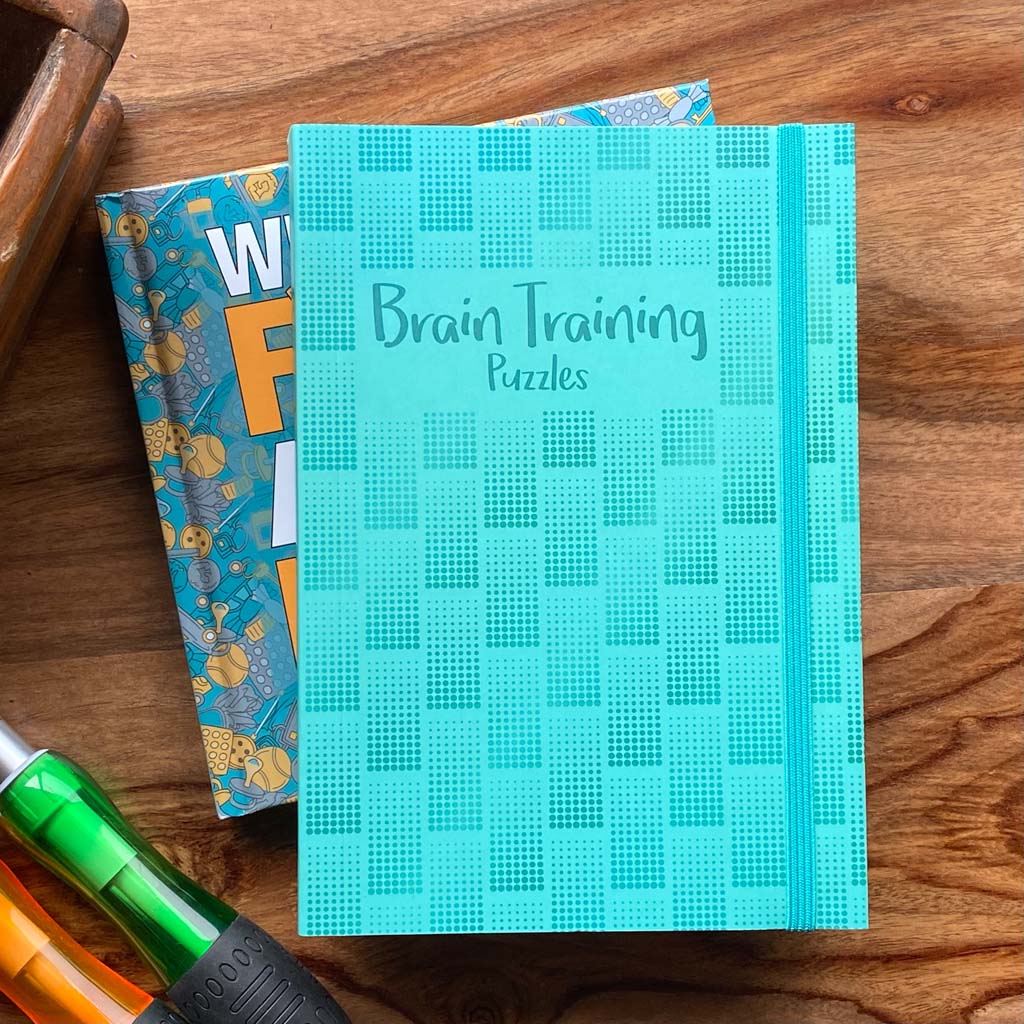 Brain training puzzles book on desk with thick pens