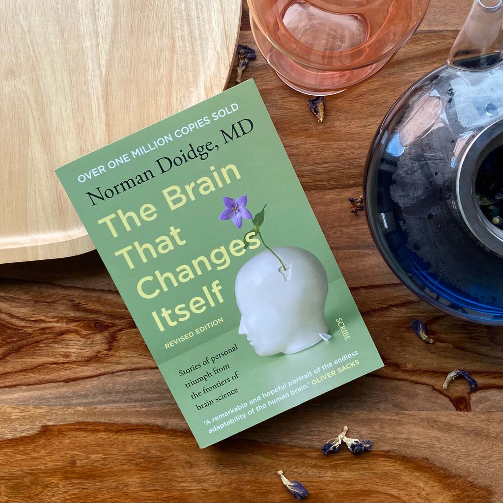 Norman Doidge The Brain That Changes Itself non-fiction book on table with tea pot