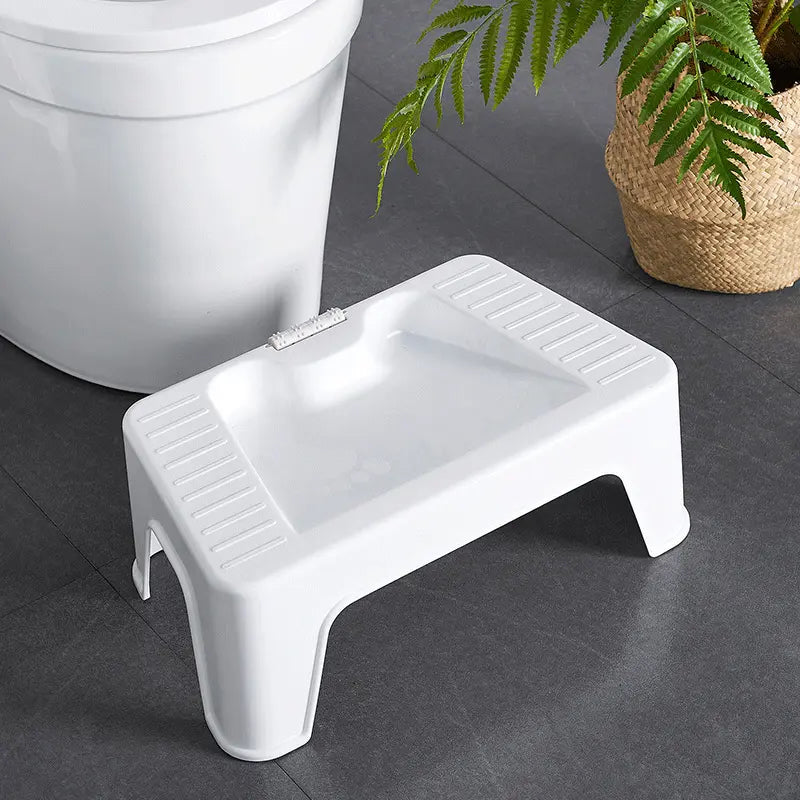 shower foot stool in white resting below toilet