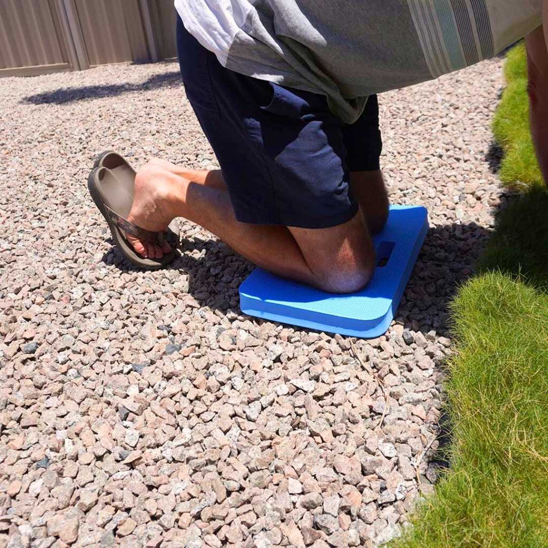 person kneeling on the kneeling pad and doing some gardening