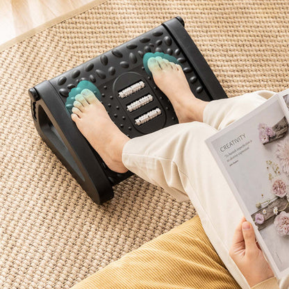 person massaging their feet with the massage dots on the black adjustable foot rest