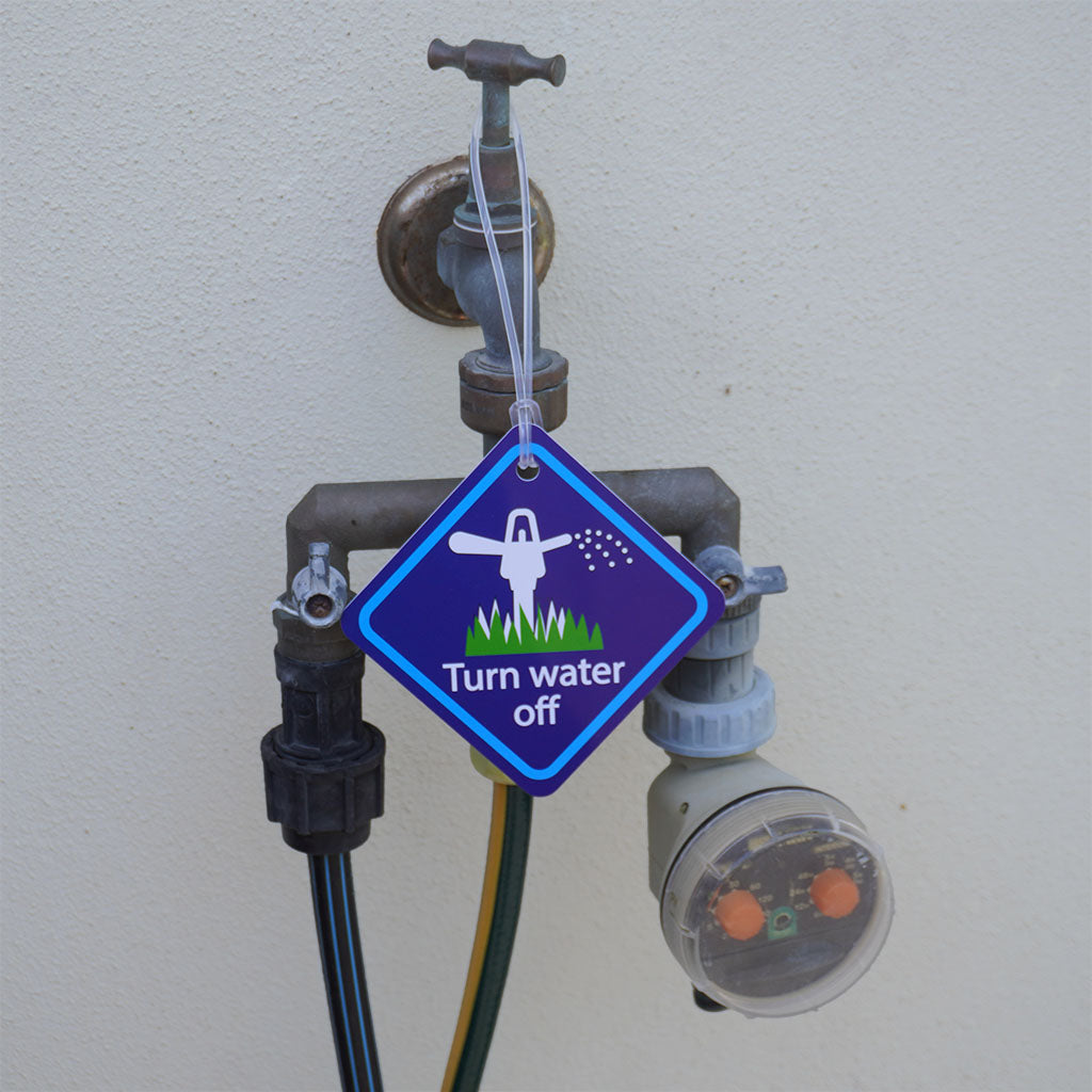 Turn off water sign hanging from outdoor tap with hose