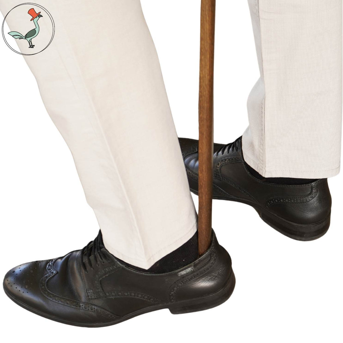 person using the extra long wooden shoe horn while standing