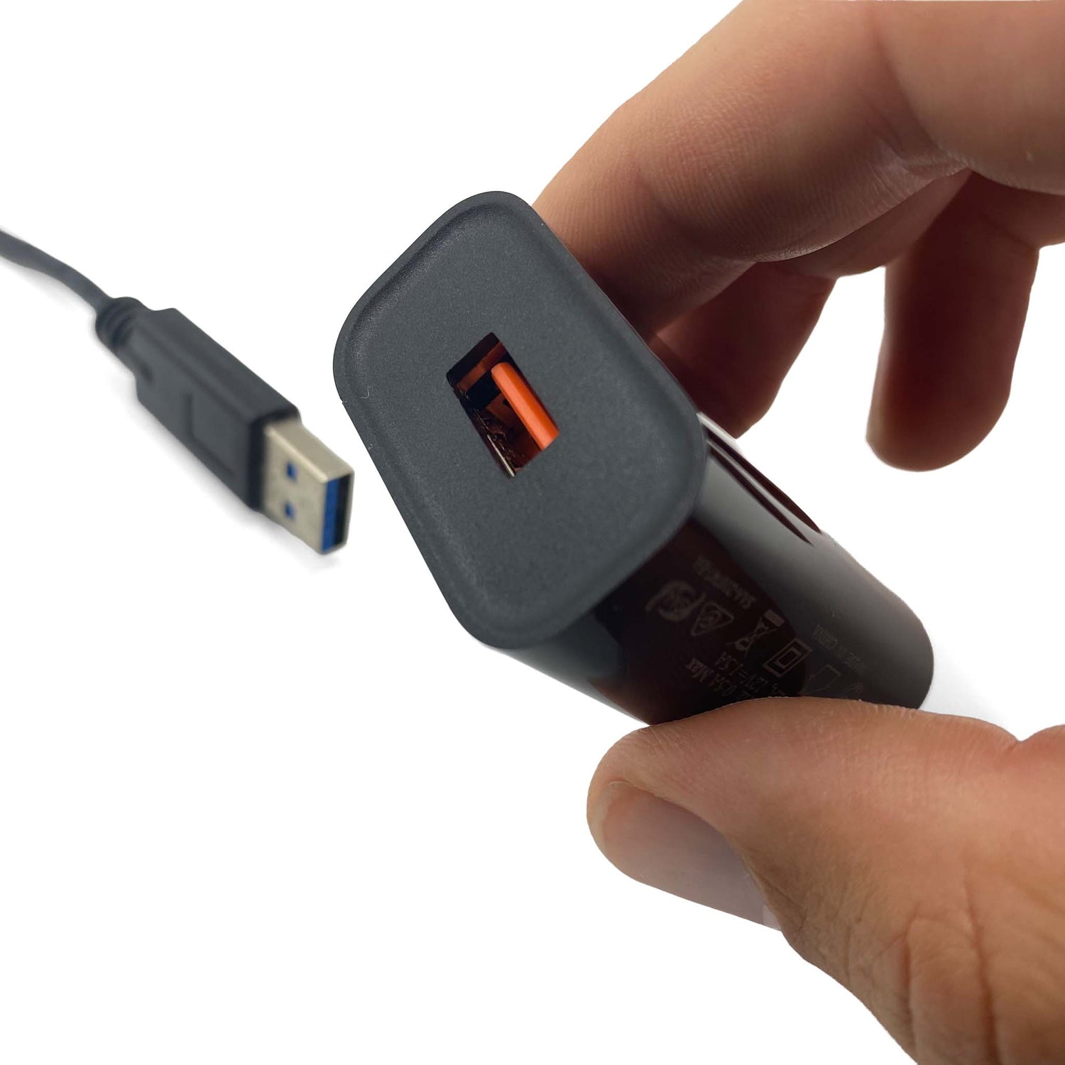 hand holding USB charger with AU plug